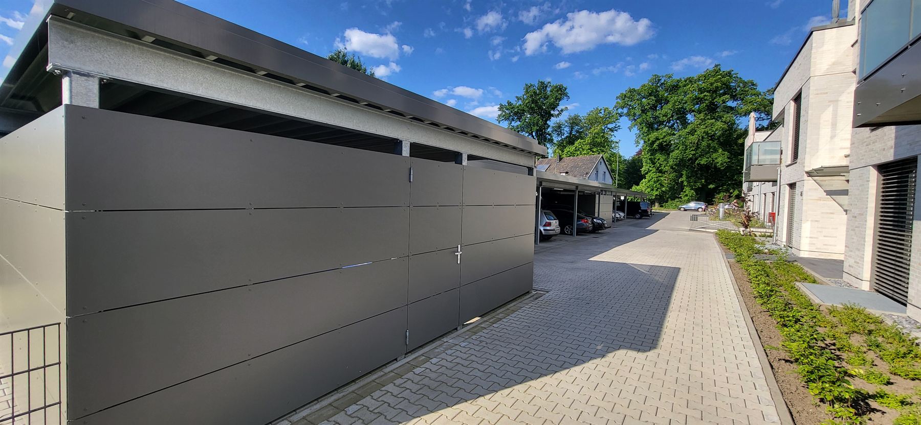 Abstellräume mit Plattenverkleidung an einer Carportanlage